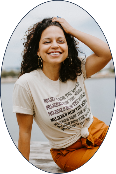 A woman is smiling and wearing a t-shirt that says Mujeres run the world.