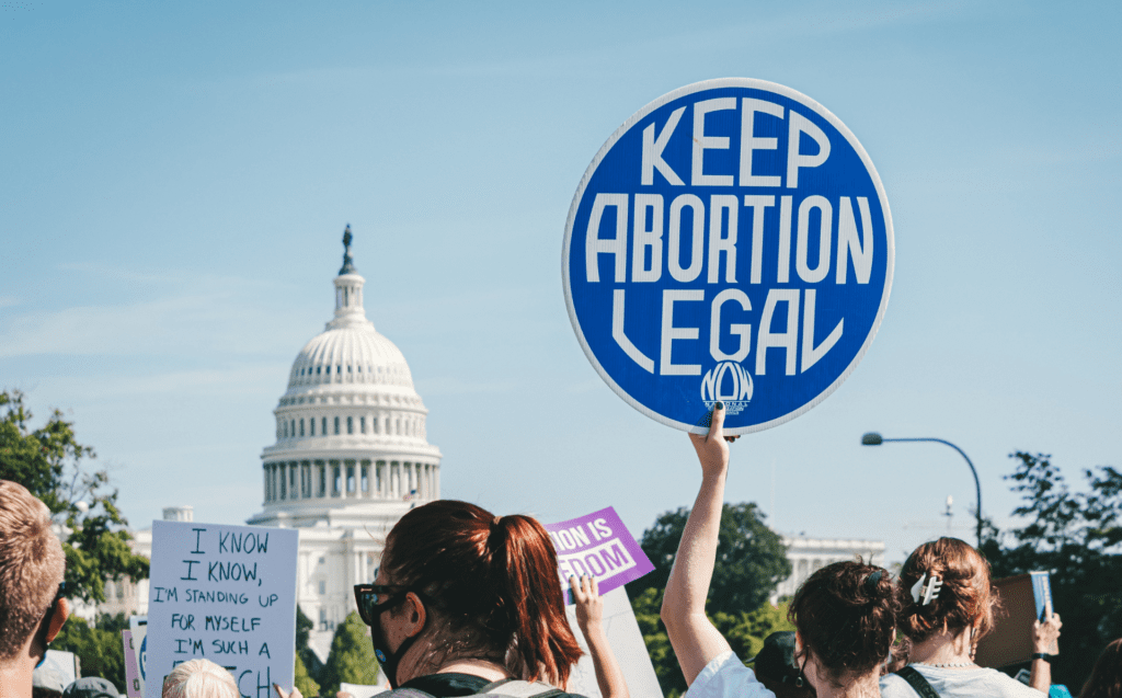 Woman holding "Keep Abortion Legal" sign as she marches in a crowd towards the Capital Building in Washington D.C. 