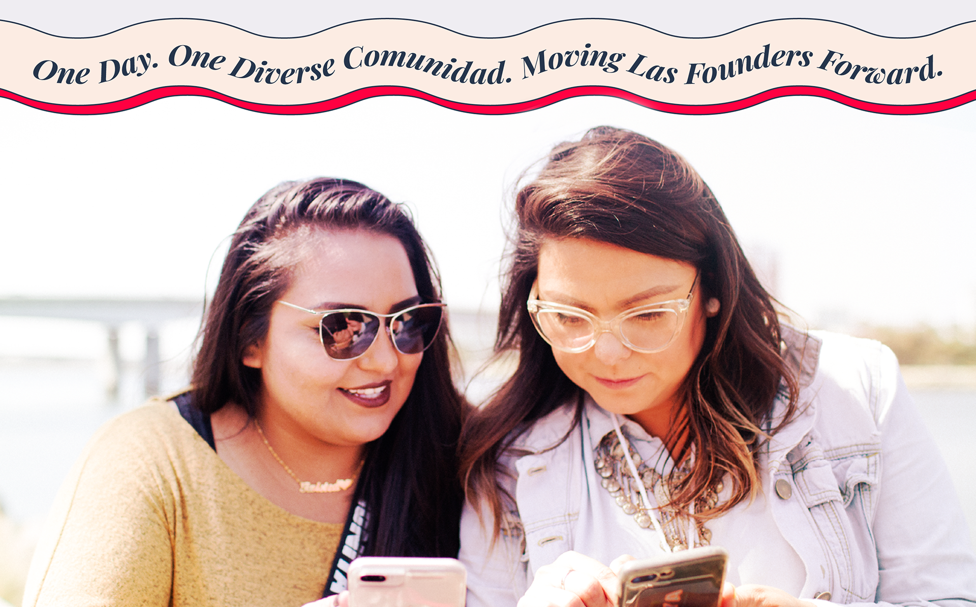 Two Latina entrepreneurs outdoors looking at a phone, with a banner on top that says "One Day. One Diverse Comunidad. Moving Las Founders Forward."