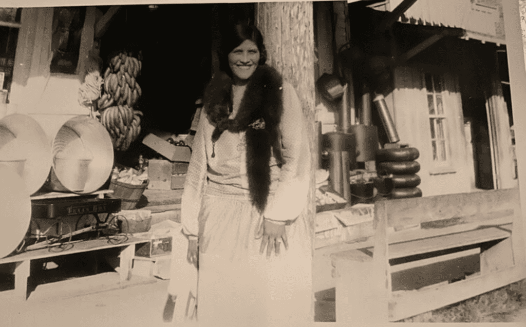 Old black and white picture of businesswoman Angelita Orea Garza in 1944 smiling in front her business, Tex-Mex Curious, an herb shop located in Texas.