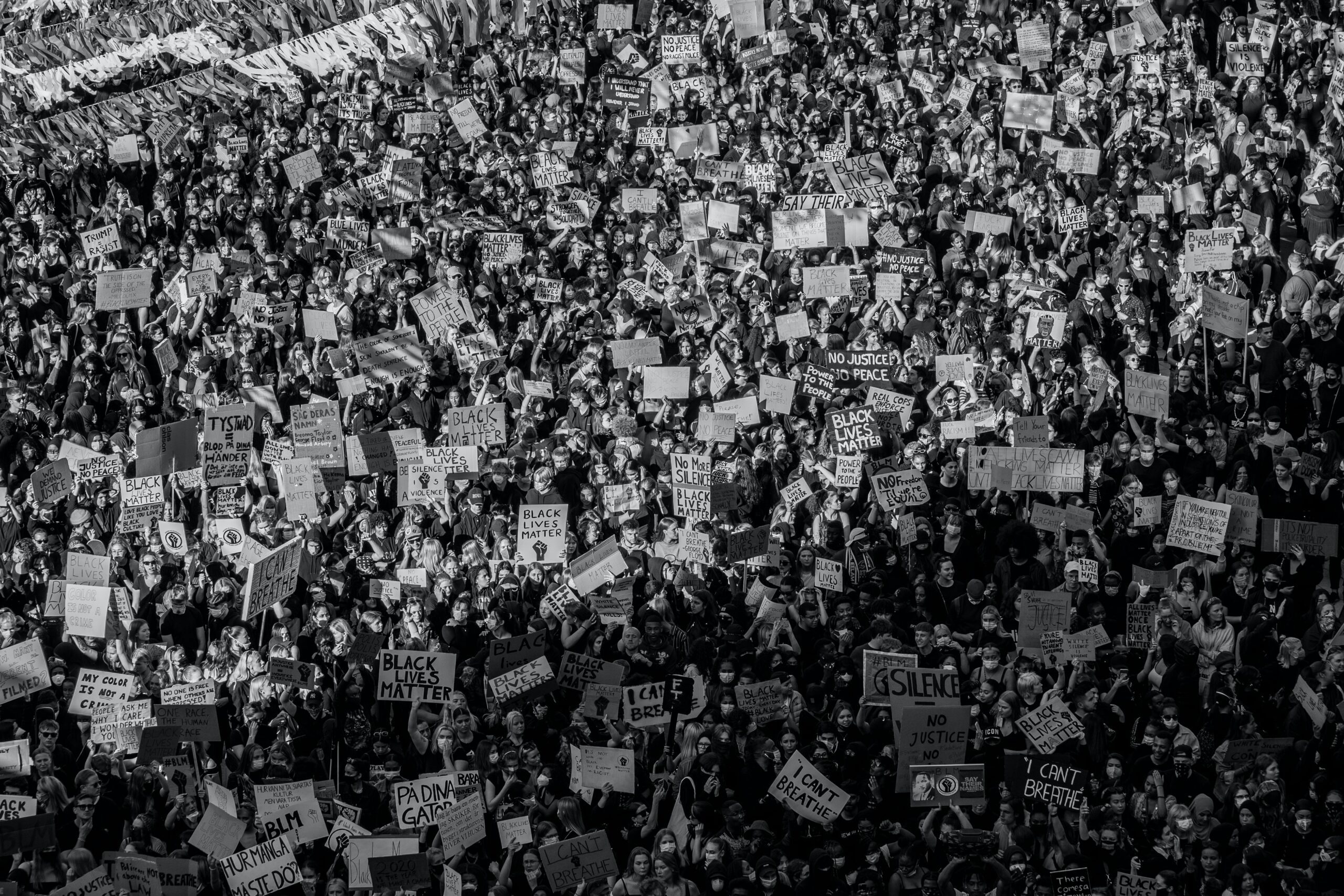 Large mass gathering of protestors at Black Lives Matter protest, with many holding signs. Photo is in black and white.