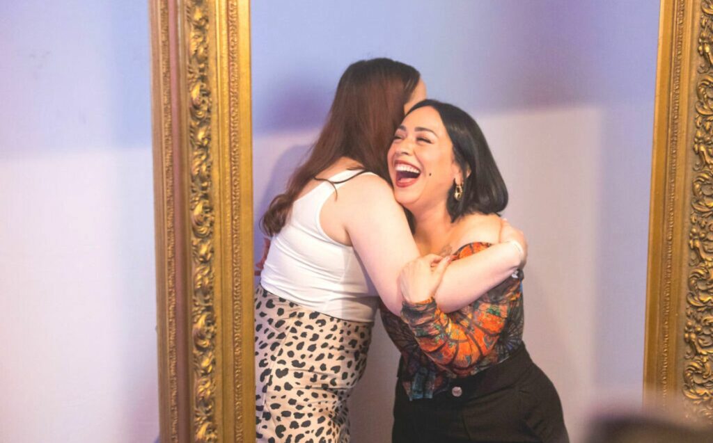 Singer-Songwriter Carla Morrison hugs an attendee at the #WeAllGrow Summit HBO Max Pa'lante Suite.
