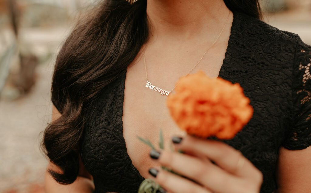 Mayra Rosas holds a Marigold in her hand –the iconic flower for Dia de Los Muertos. It's in honor of her parent who passed away.